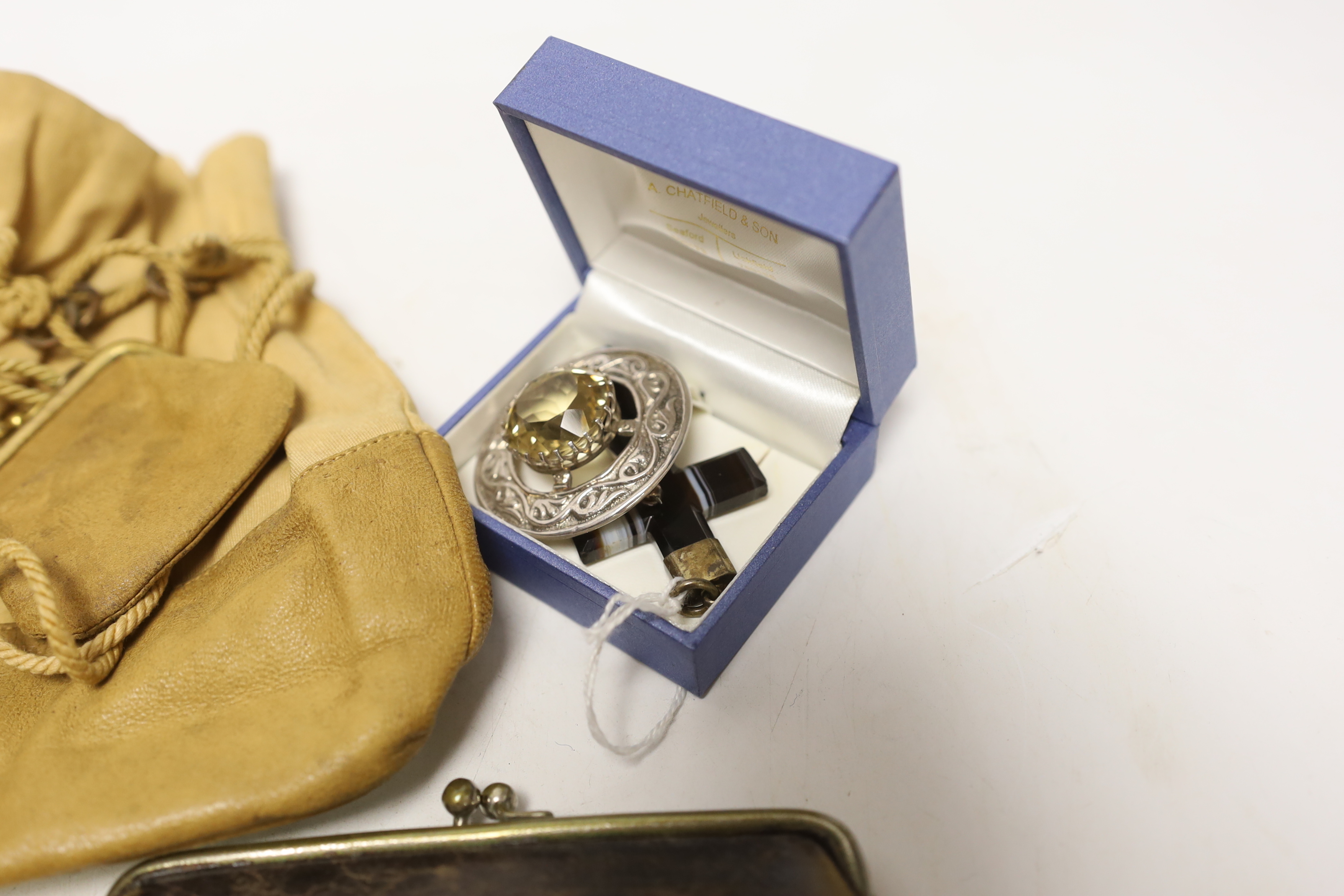 A group of collectables including a bell, a matchbox holder, a pendant, a brooch, etc.